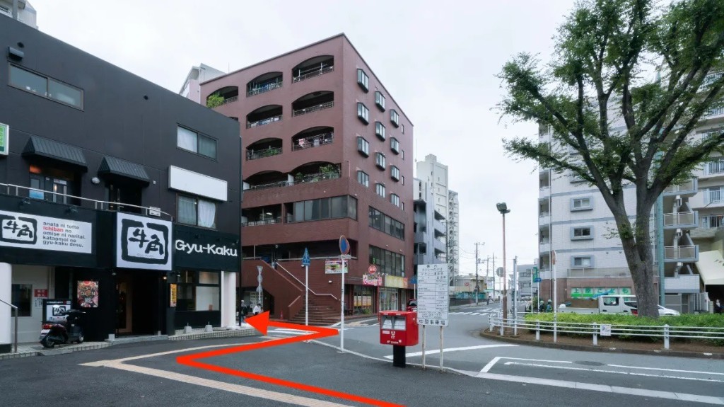 牛角と赤いビルの間の路地。赤い矢印の通り