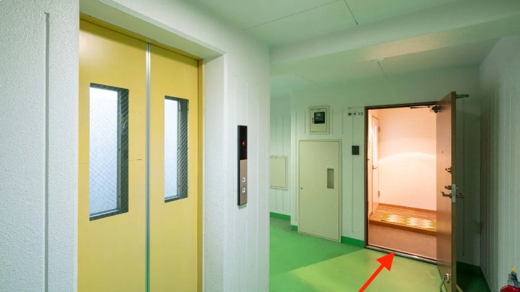 4階 廊下。エレベーター表示「4」。開いた扉先が403号室「健康庵 日々樹」。赤い矢印の先へ
